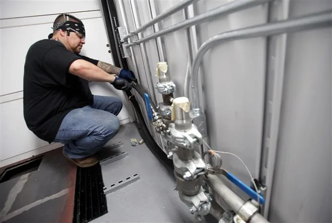 IEA Worker works on plumbing for cooling in a secured shipping container that will house a U.S. Army cloud computer network.